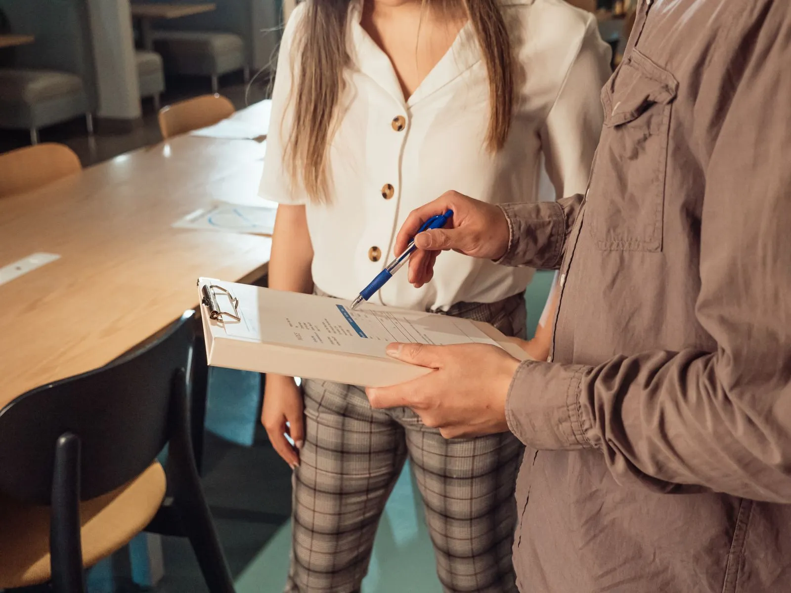 Two people reviewing notes on a clipboard